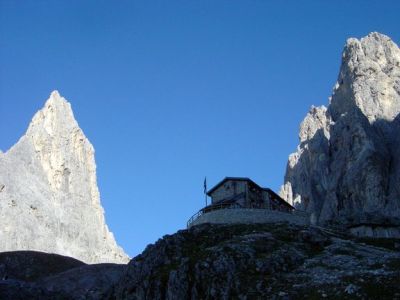 Il Rifugio Pradidali al mattino. Lentamente il sole fa capolino tra le cime, illuminando gradualmente il paesaggio.