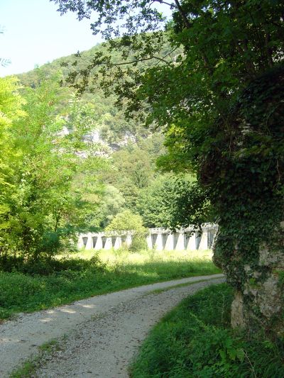 In lontananza il Canale di Soccher, sospeso da arcate che vagamente ricordano un acquedotto romano.