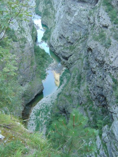 Il torrente Vajont e la sua stretta e profonda gola. Sugli specchi d'acqua più grandi si riflettono le cime assolate.